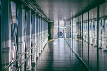 Pasarela de embarque vacía con un avión al fondo