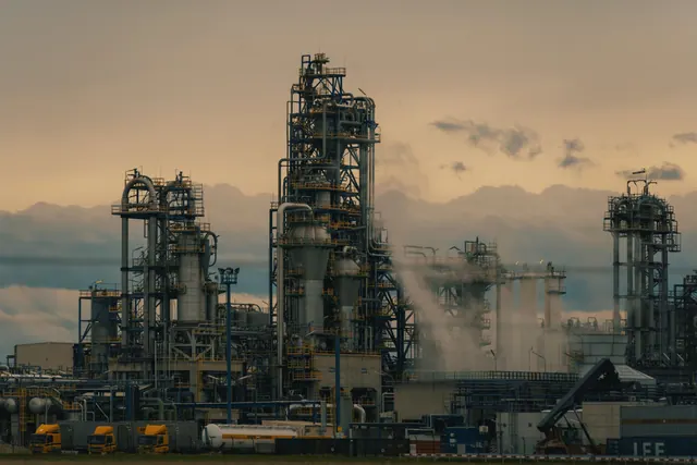Torres y tuberías de una refinería industrial al atardecer