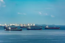 Varios petroleros fondeados junto a tanques de almacenamiento en una bahía
