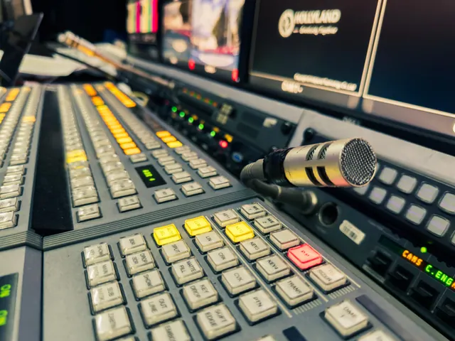 Sala de control de un estudio de televisión con monitores apagados y mesa de mezclas