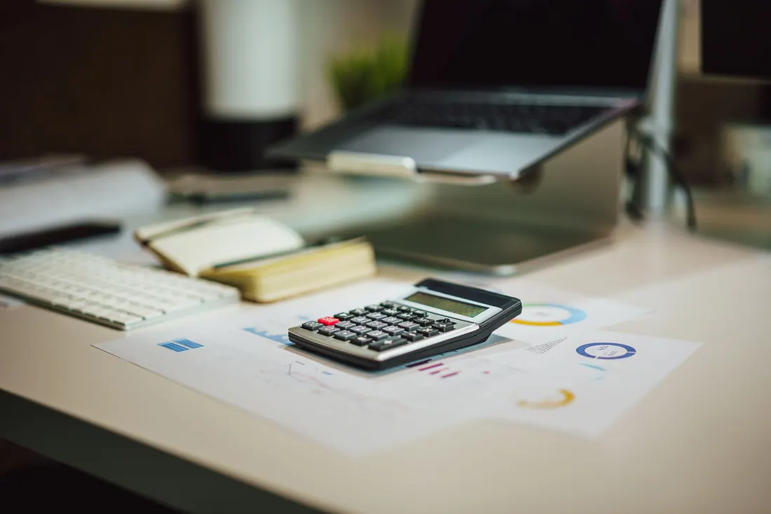 Calculadora sobre gráficos financieros en un escritorio de oficina