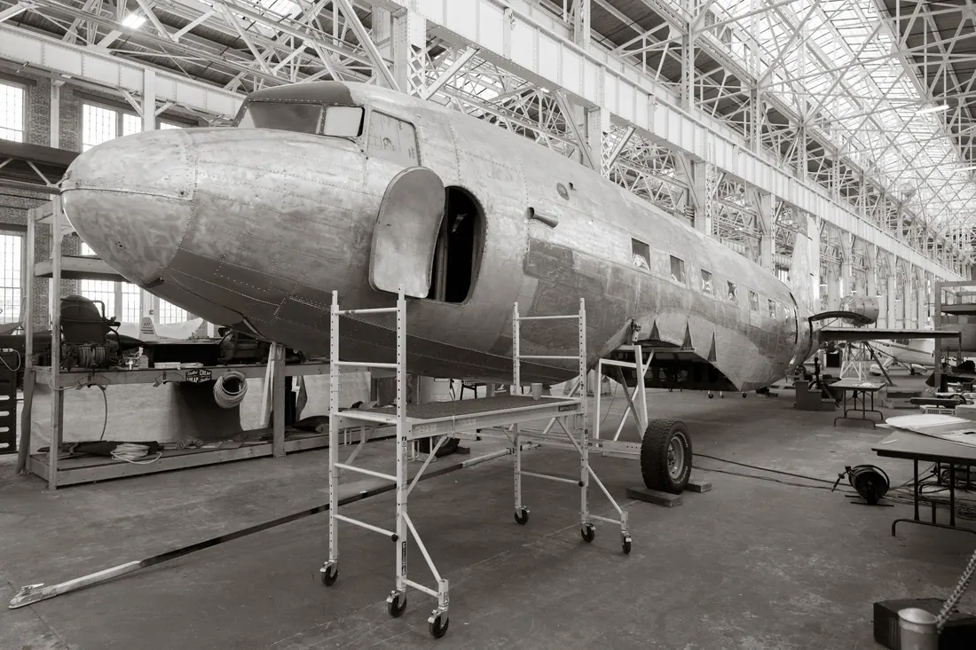 Interior de una nave industrial de montaje aeronáutico con estructuras metálicas