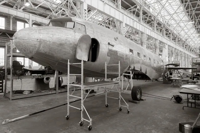 Interior de una nave industrial de montaje aeronáutico con estructuras metálicas