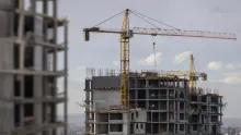 Edificio de apartamentos en construcción con grúas y estructura de hormigón sin terminar