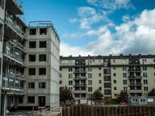 Edificio en construcción junto a bloques de viviendas terminados
