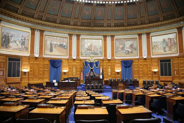 Sala de reuniones institucional vacía con mesa larga y sillas