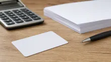 Escritorio con calculadora, bloc de notas, bolígrafo y tarjeta en blanco