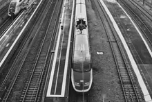 Vista aérea de un tren entrando en una estación con varias vías
