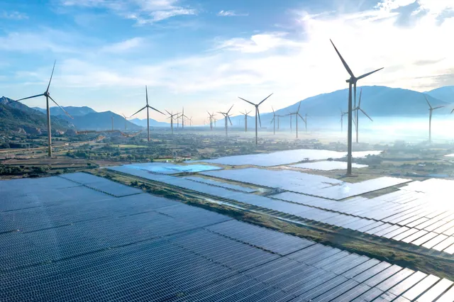 Parque de placas solares y aerogeneradores en un valle montañoso