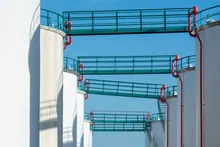 Tanques de almacenamiento industrial conectados por pasarelas metálicas