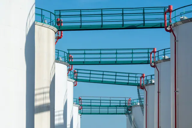 Tanques de almacenamiento industrial conectados por pasarelas metálicas