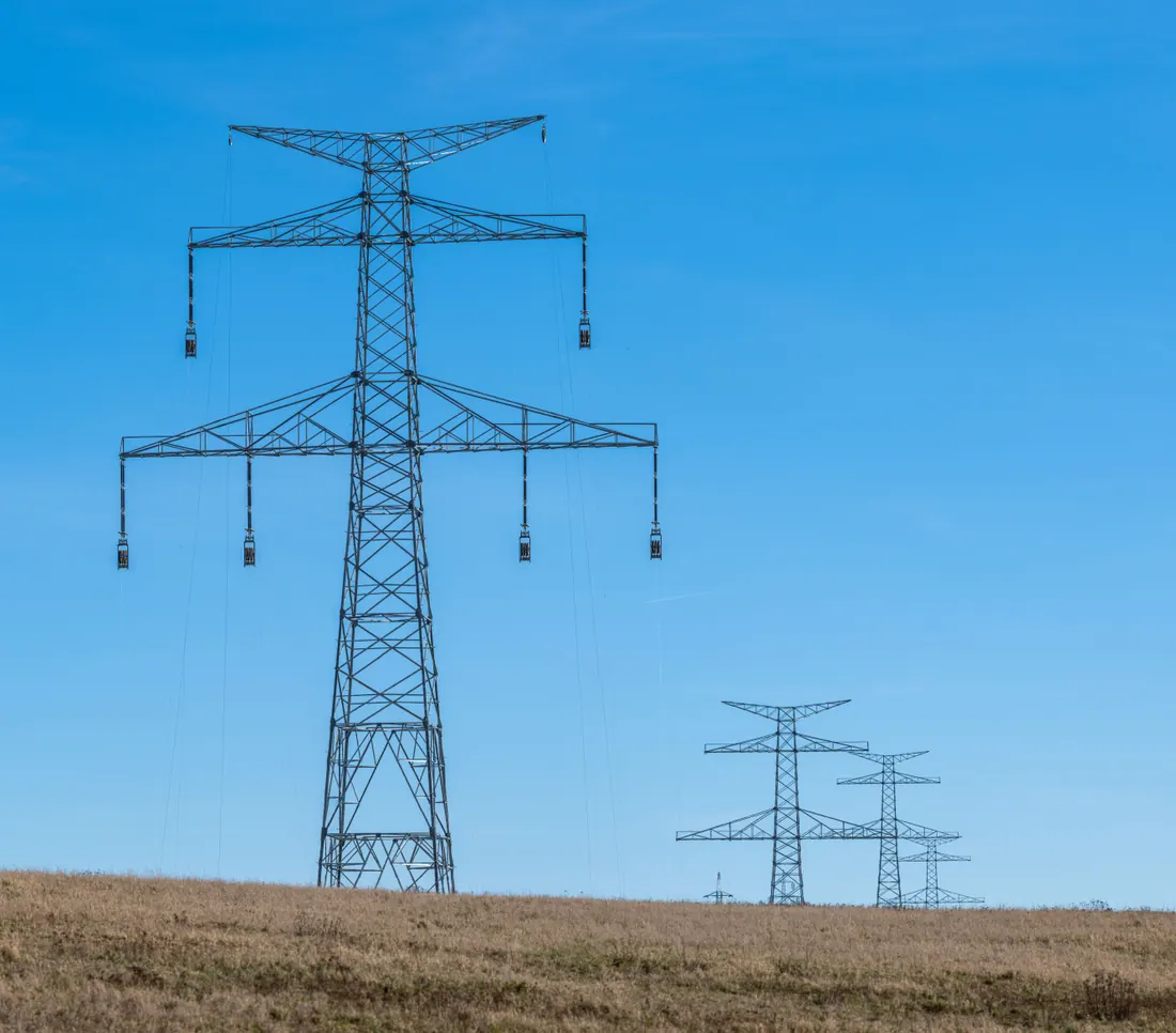 Torres de alta tensión en un campo bajo un cielo despejado