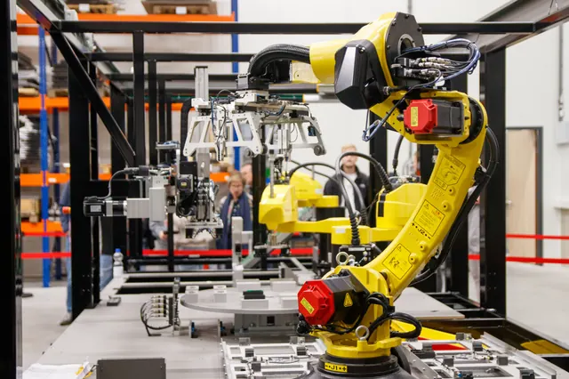 Línea de montaje de automóviles con brazos robóticos y carrocerías sin pintar