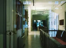 Pasillo de un edificio institucional con cuadros y vitrinas
