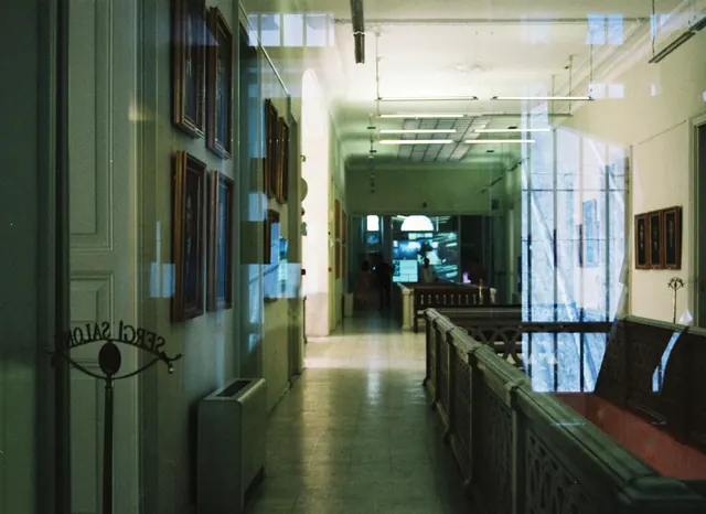 Pasillo de un edificio institucional con cuadros y vitrinas