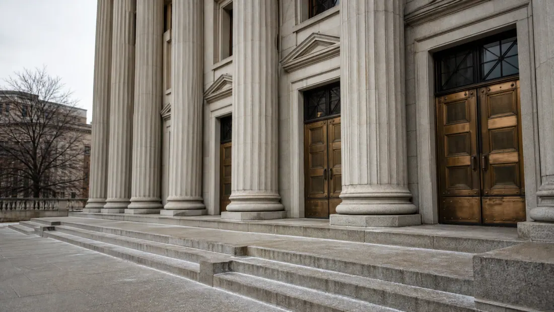 Fachada de edificio neoclásico con columnas y puertas de bronce