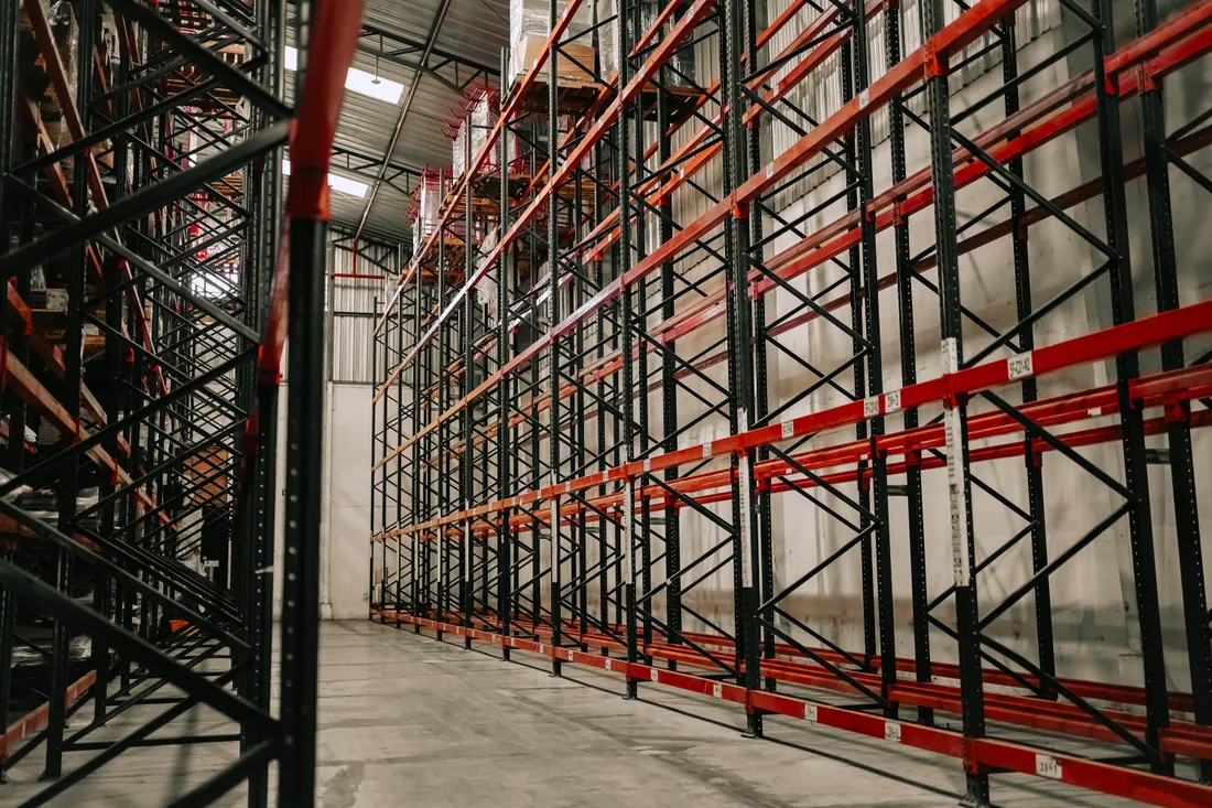 Perchas con ropa y cajas de cartón en un almacén logístico textil
