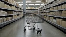 Carrito de compra vacío en pasillo de supermercado con estanterías