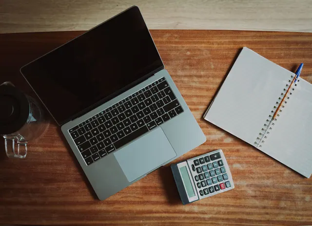 Documentos de nómina y una calculadora sobre una mesa de oficina