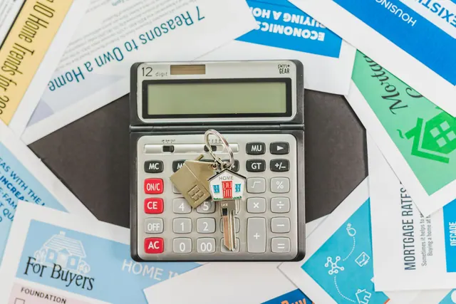Llaves de una vivienda junto a documentos sobre una mesa de madera