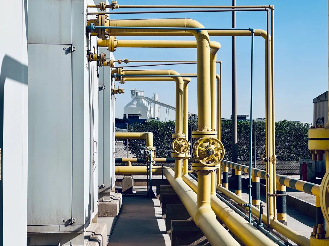Tuberías amarillas de gas con válvulas en una planta industrial