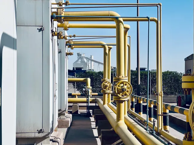 Tuberías amarillas de gas con válvulas en una planta industrial