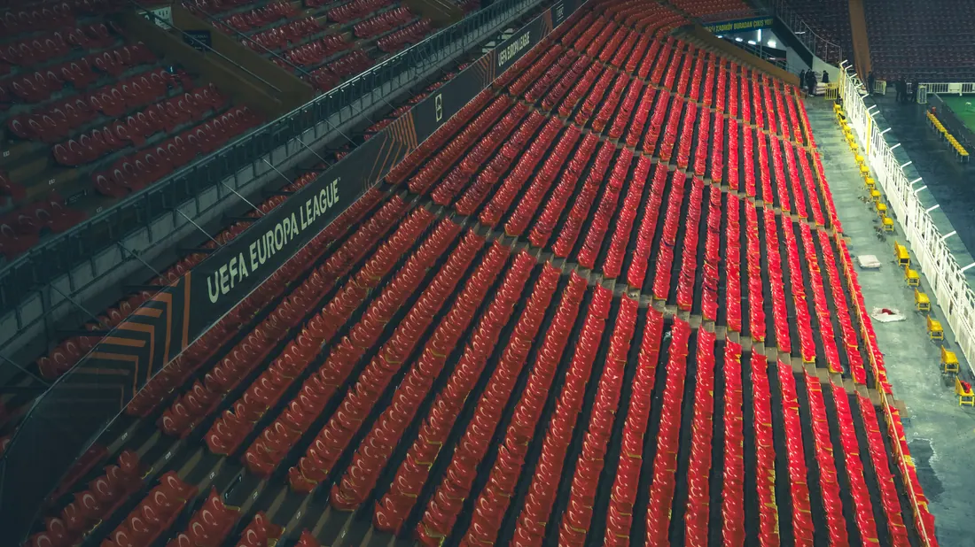 Estadio de fútbol vacío, con las gradas iluminadas antes de un partido