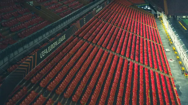 Estadio de fútbol vacío, con las gradas iluminadas antes de un partido