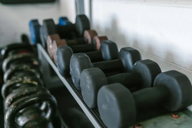 Mancuernas ordenadas en un estante de un gimnasio