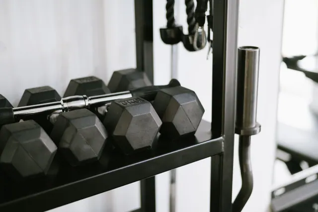 Mancuernas hexagonales apiladas en un estante de un gimnasio