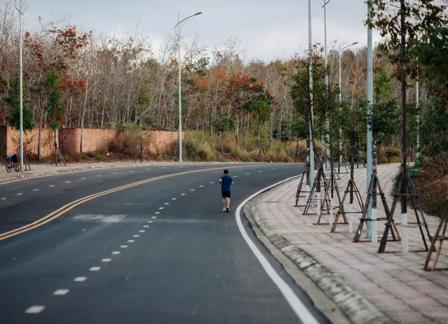 Una persona corre por una carretera junto a un bosque