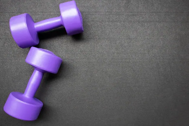 Dos mancuernas moradas sobre una superficie oscura