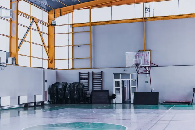 Pabellón deportivo vacío con canasta de baloncesto