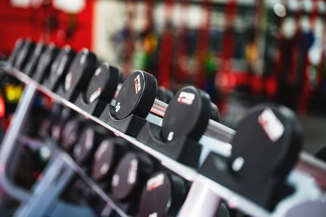 Mancuernas ordenadas en un estante de un gimnasio