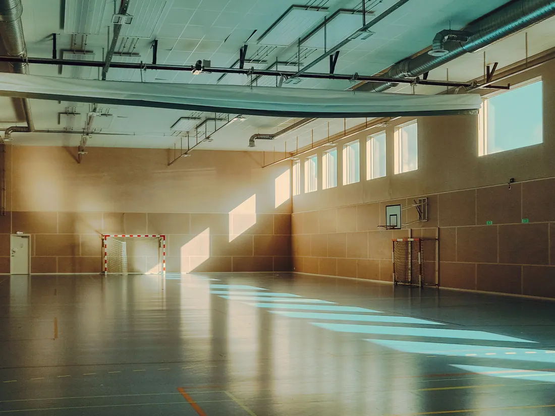 Pabellón polideportivo vacío con porterías y canasta de baloncesto