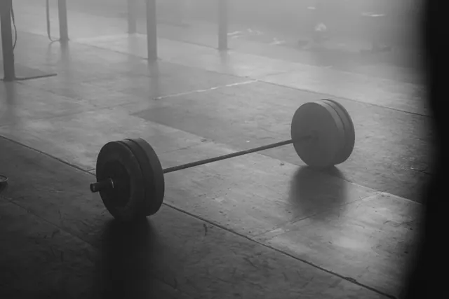 Una barra de pesas en el suelo de un gimnasio