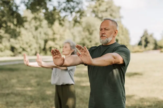 Dos personas mayores practicando taichí en un parque