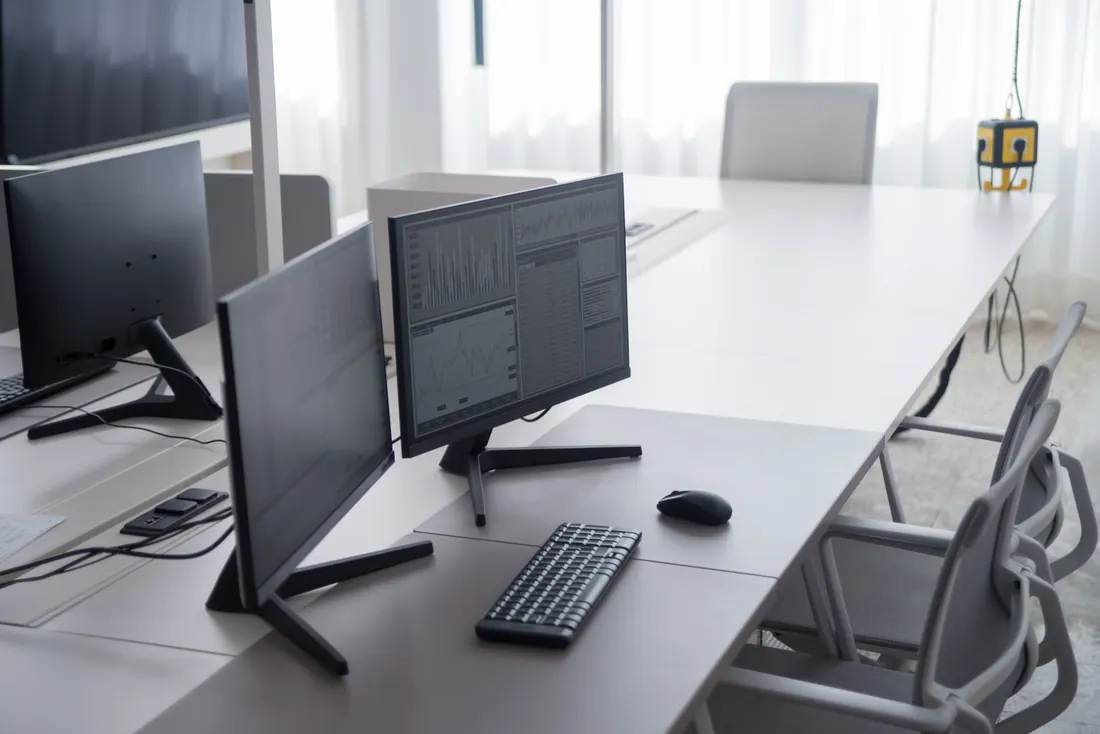 Monitores con gráficos financieros en una mesa de oficina