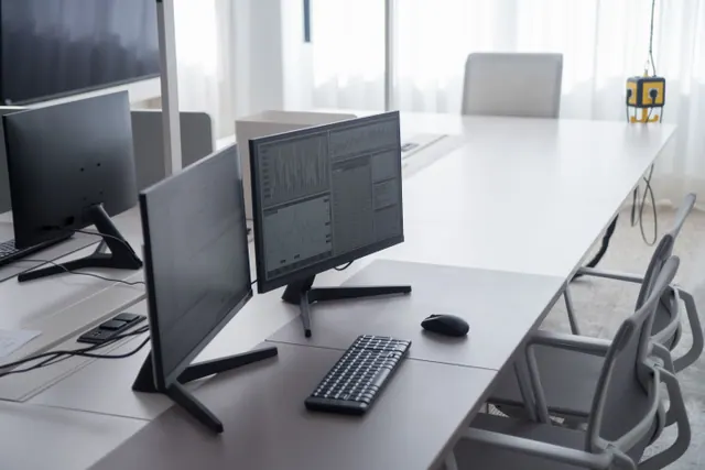 Monitores con gráficos financieros en una mesa de oficina