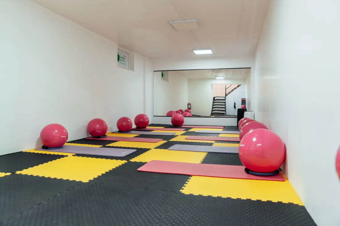 Sala de un gimnasio con esterillas y pelotas de pilates