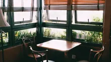 Mesa con sillas junto a ventanales con vistas a vegetación