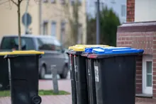 Contenedores de reciclaje de colores en una calle residencial