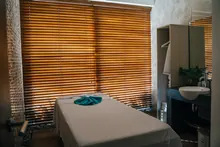 Camilla de masajes en una sala de spa con persianas de madera