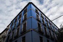Edificio de esquina con fachada azul y balcones de hierro forjado en estilo arquitectónico clásico