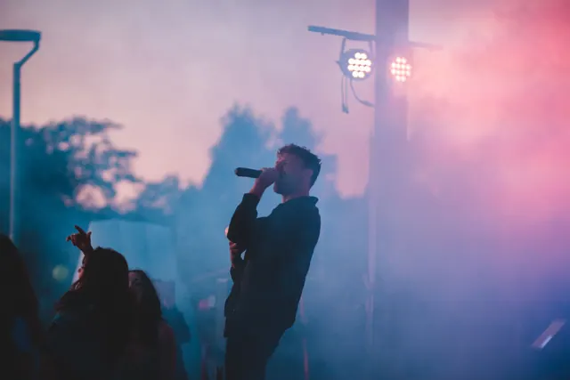 Escenario de conciertos al aire libre con equipo de luces y vallas vacías
