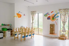 Aula infantil con mesas, sillas y decoración colorida en las paredes