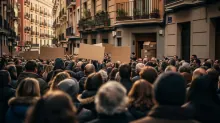 Multitud de personas en una calle urbana con carteles en blanco durante