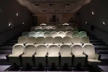 Interior de una sala de cine vacía con butacas en filas