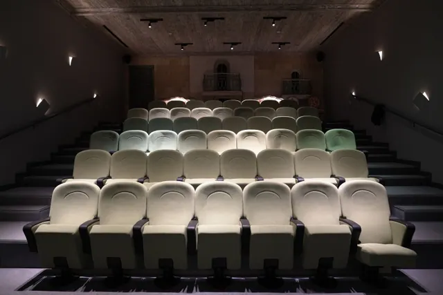 Interior de una sala de cine vacía con butacas en filas