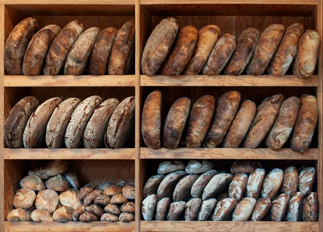 Estanterías de madera con panes recién horneados en una panadería